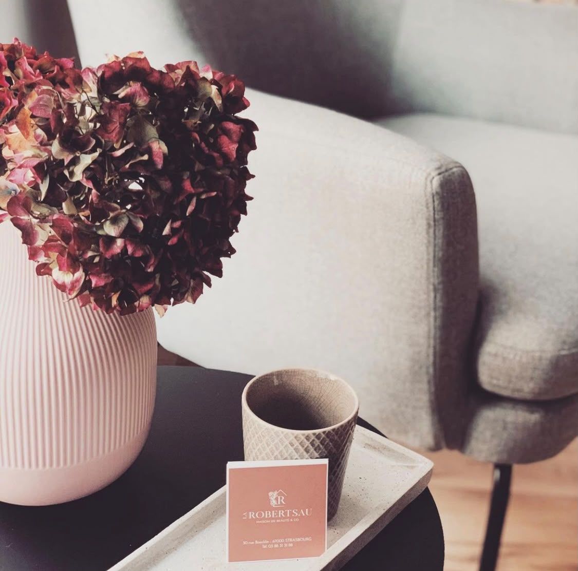 Le coin salon de l'institut&nbsp;: fauteuil, bouquet d'hortensias et carte de La Robertsau posée sur un plateau
